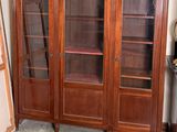 un grand meuble en bois avec des portes en verre dans une pièce
