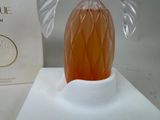 a glass angel figurine sitting on a white table