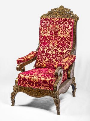 une chaise rouge et dorée posée sur un sol blanc
