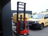 a yellow van and a red forklift in a parking lot