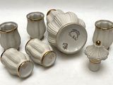 un ensemble de vases et de tasses blancs posés sur une surface blanche