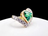 an image of a heart shaped emerald and diamond ring on a white plate