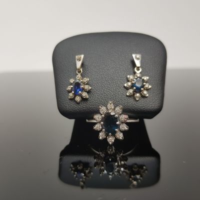 un gros plan d'un ensemble composé d'un collier et de boucles d'oreilles, présenté sur un présentoir