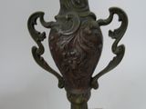a bronze vase on a marble base on a white background