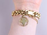 gold bracelet with a heart charm and a chain on a woman ' s wrist
