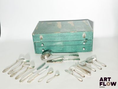 une boîte verte contenant de l'argenterie, posée sur une table blanche