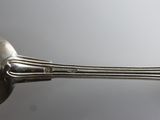 silver plated spoon and spoon rest on a white surface