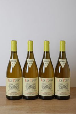 quatre bouteilles de vin sont alignées sur une table en bois