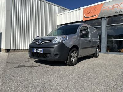 La camionnette est garée devant un immeuble sur lequel est accrochée une pancarte.