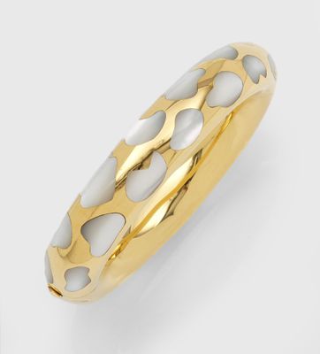 un gros plan d'une bague dorée et blanche sur fond blanc