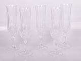 four clear wine glasses sitting on top of a white table