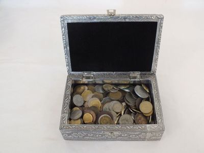 a silver box filled with coins sitting on a table