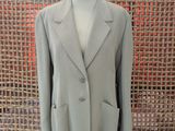 a suit on a mannequin stand in front of a woven wall