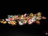 a pile of multicolored glass beads on a black surface