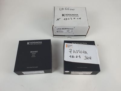 trois boîtes contenant du matériel électronique posées sur une surface blanche