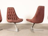 three brown chairs sitting next to each other on a cement floor