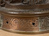 a bronze statue of a woman sitting on a pedestal