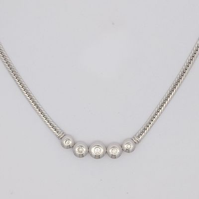un gros plan sur un collier en argent porté par un mannequin