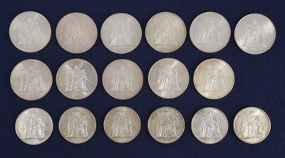 a group of twenty silver coins with the image of jesus on them