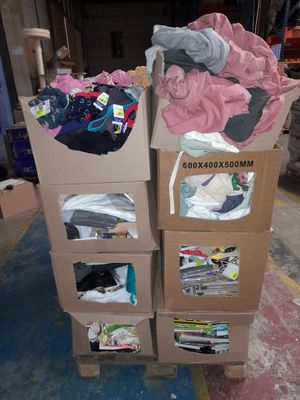 deux cartons sur lesquels sont posés des vêtements, dans un entrepôt