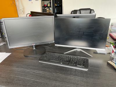 deux écrans d'ordinateur et un clavier sur un bureau