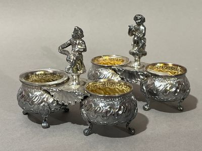 trois pots en argent surmontés d'une statuette, placés les uns à côté des autres