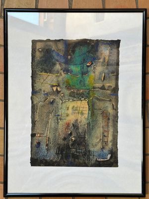 tableau représentant un oiseau vert dans un cadre noir, accroché à un mur de briques
