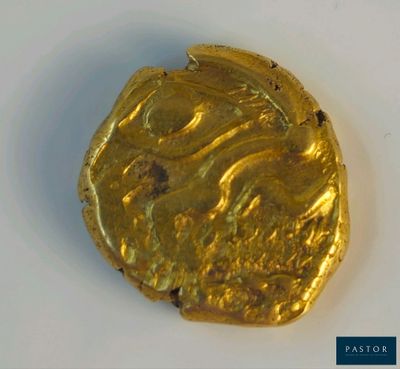 une pièce d'or posée sur une surface blanche