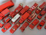 a lot of red toy trucks that are on a table