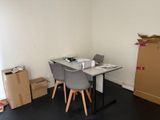a table and chairs in a room with boxes on the floor