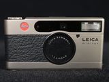 a silver and black camera on a black surface