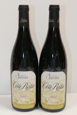 two bottles of red wine sitting on a table next to each other
