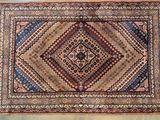 un vieux tapis orné d'un motif en losanges au centre