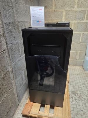 a black stove sitting on a pallet in a bathroom