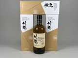 une bouteille de whisky vide posée devant un carton