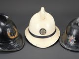 three firemen hats are lined up in a row on a black background