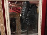 un miroir posé par terre à côté d'une pile de chaises