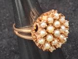 a gold ring with pearls on top of a cone
