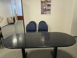une photo d'une salle de réunion avec des chaises et une table