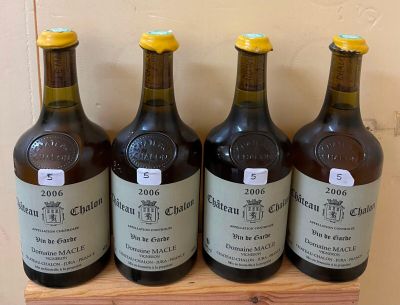 six bottles of wine are lined up on a wooden shelf