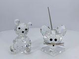 crystal figurines of a mouse and a cat on a white surface
