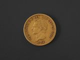 a close up of a gold coin on a black surface
