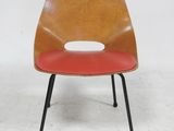 an orange and black chair with a red seat on a white floor