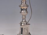 an antique silver plated lamp with a cord attached to it