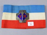 une image représentant un drapeau bleu, blanc et rouge orné d'un insigne