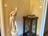 une statue dans un coin de la pièce, à côté d'une petite table