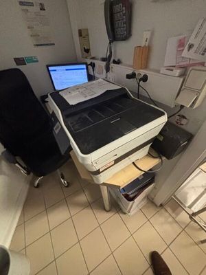 a laptop computer sitting on a desk in a room