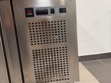a stainless steel trash can sitting in the middle of a tiled floor