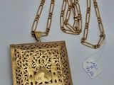 une photo d'un collier en or sur lequel figurent les portraits d'un homme et d'une femme