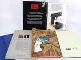 two books on the table with a gun on it
